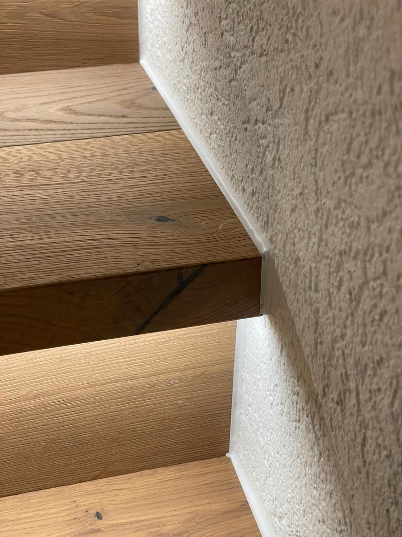 Trittkante aus Eiche an einer verputzten Wand